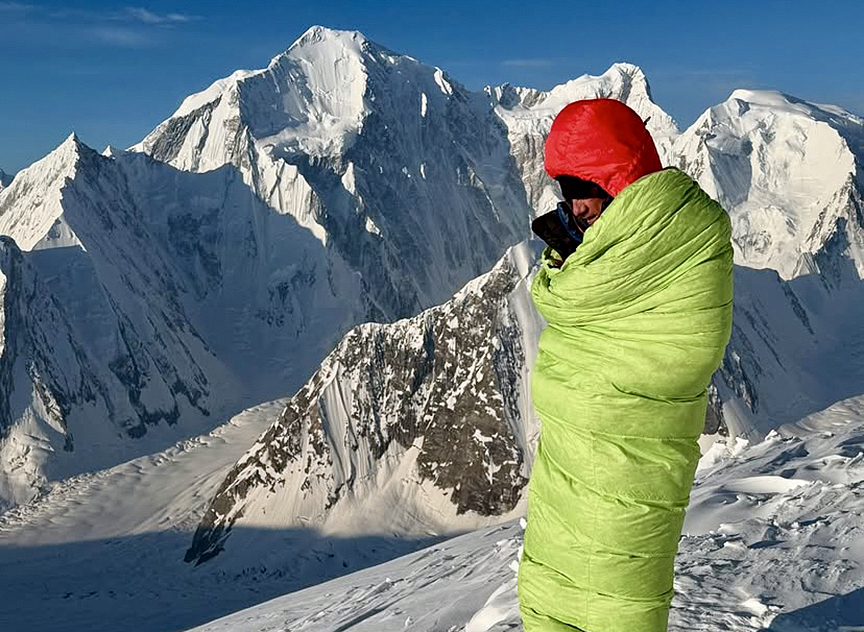 guy standing on snowy mountain in sleeping baag