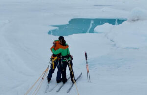two skiers in overcast weather embrace