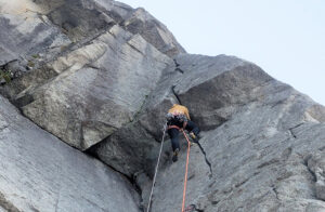 A climber on a granite roof.