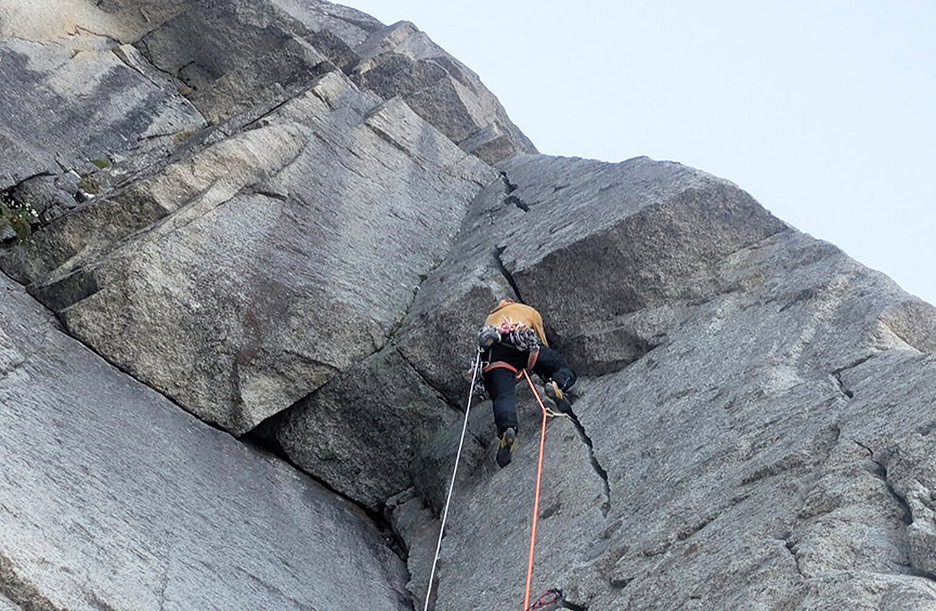 A climber on a granite roof.