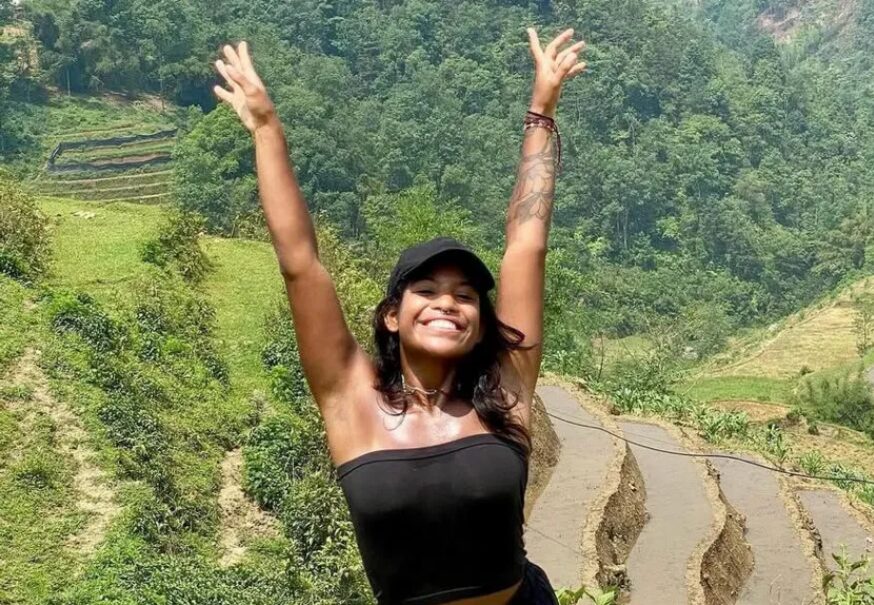 A young woman raising her arms and smiling