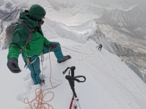 David Goettler on the summit of baruntse in a foggy day, with ice axe in the snow and rope.