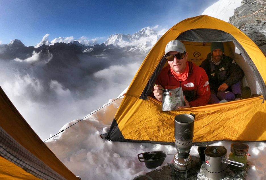 Goettler looks out from inside a tent pitched on a snowy ridge.