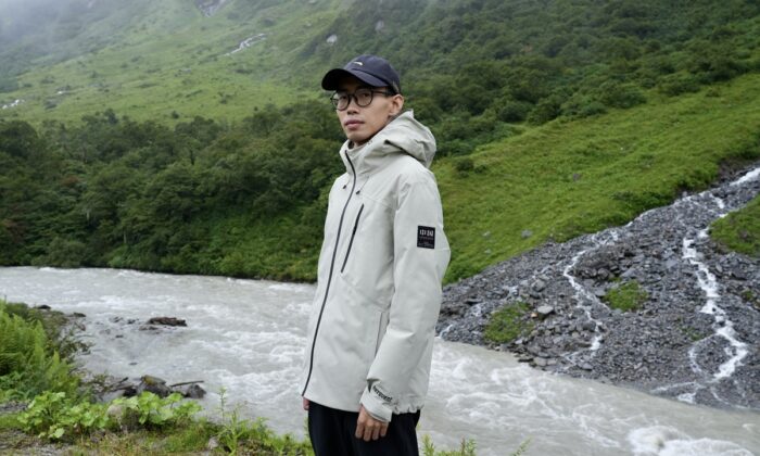 Ma Chunlin, photographer, posing in front of a mountain river.