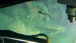 A photo from a submarine of an algae-covered ship's wheel.