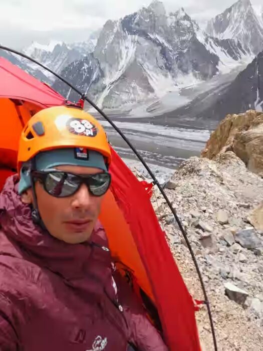 The climber in front of his tent on rocky terrain