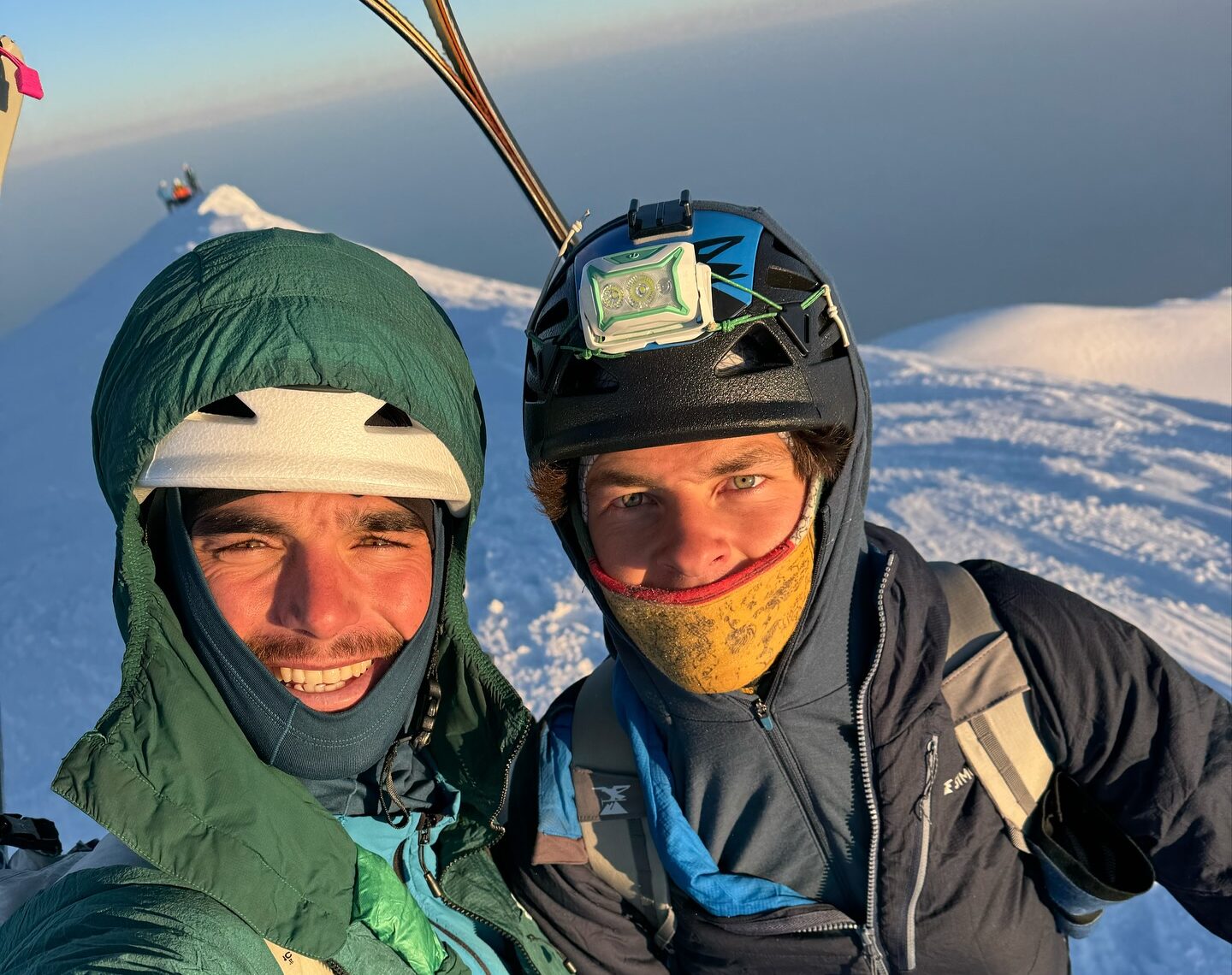 Close shot of Vedrines and Jean with the sunrise light on their faces as they stand in a the snowy summit of Mont Blanc.