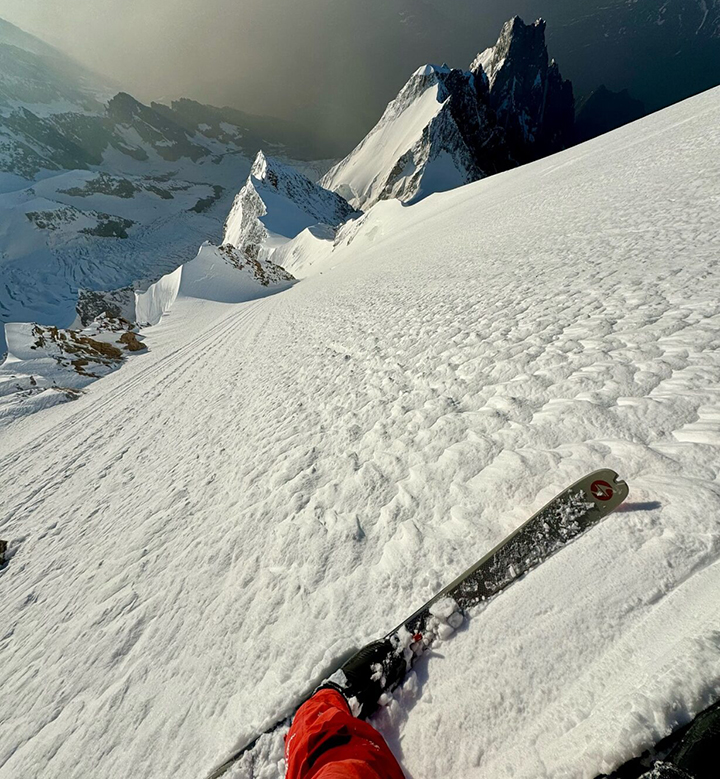 A skier photographs the highly steep descent he is about to do, down a snow ramp on Mont Blanc.
