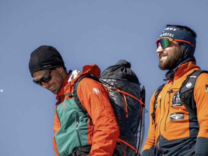 Close shot of Ales Cesen and Lukas Woerle in mountain clothes.
