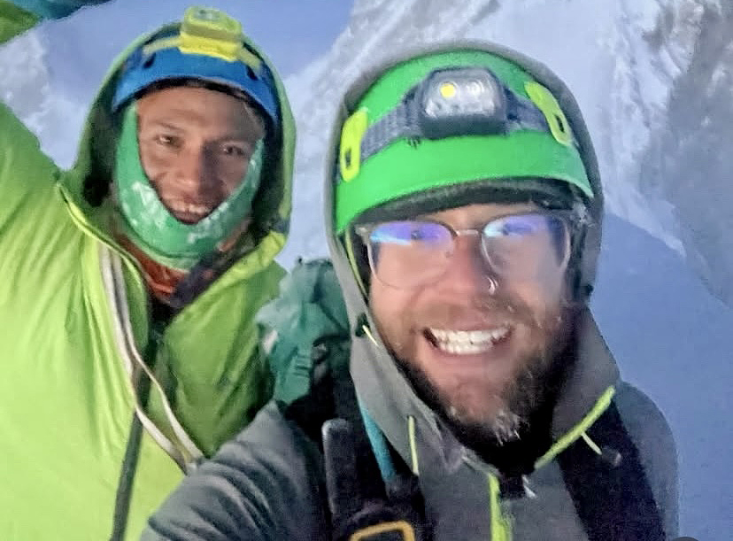 portrait of two smiling climbers in snow