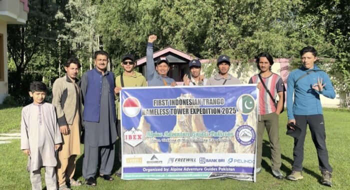 Climbers with some locals and an expedition banner.