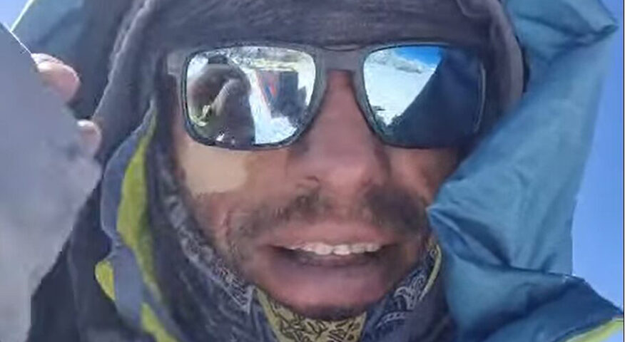 Close shot of Waldemar on a summit, with sunglasses and down hood.
