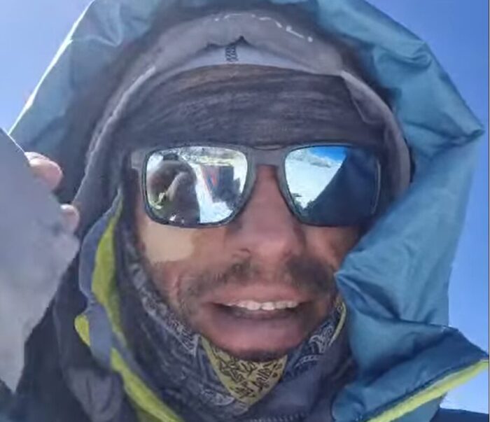 Close shot of Waldemar on a summit, with sunglasses and dawn hood.