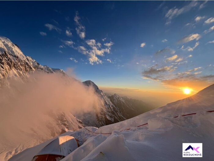 Sunset from the mountains as seen at Camp 2 by a snowy ridge on Nanga Parbat, with clouds approaching from one side.