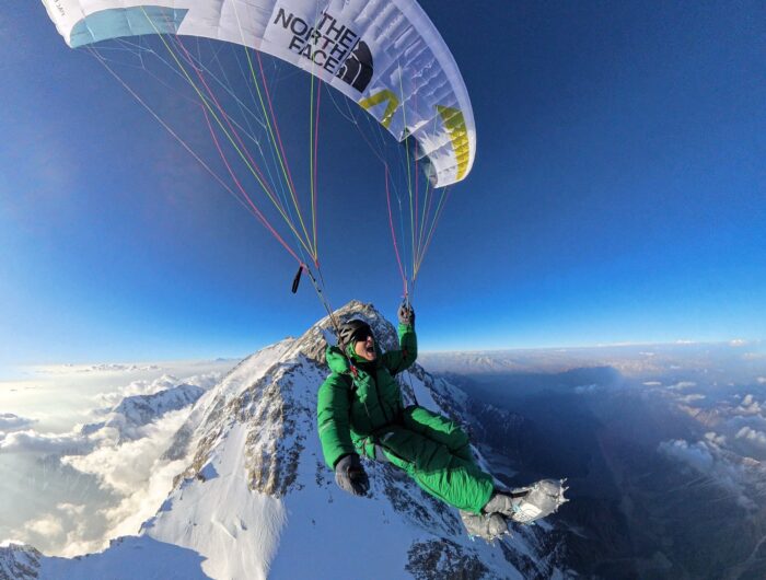 David Goettler takes a selfie as he paraglides from the top of Nanga Parbat at down, the mountain and the horizon at his feet.