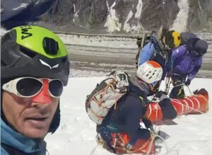 group of rescuers begin to lower injured climber down