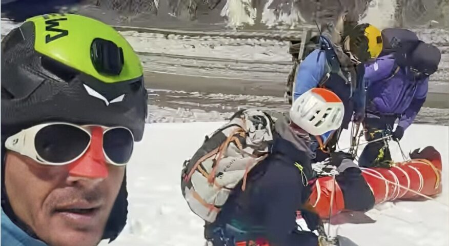 group of rescuers begin to lower injured climber down