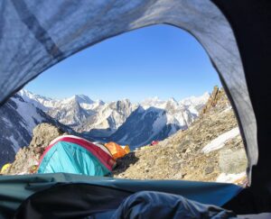 Tents on rocky terrain as seen from inside another tent.