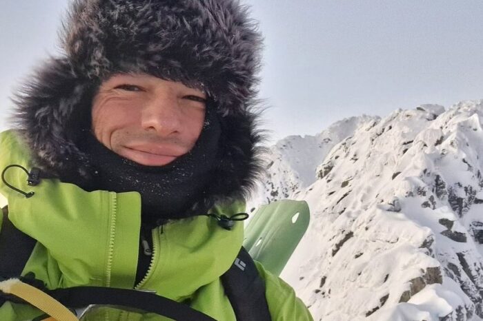 Close shot of Kowalewski with a fur hat and a mountain in background.