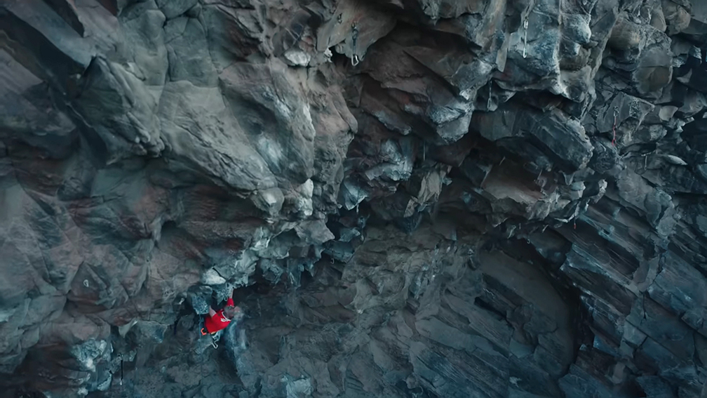 man climbing in red shirt