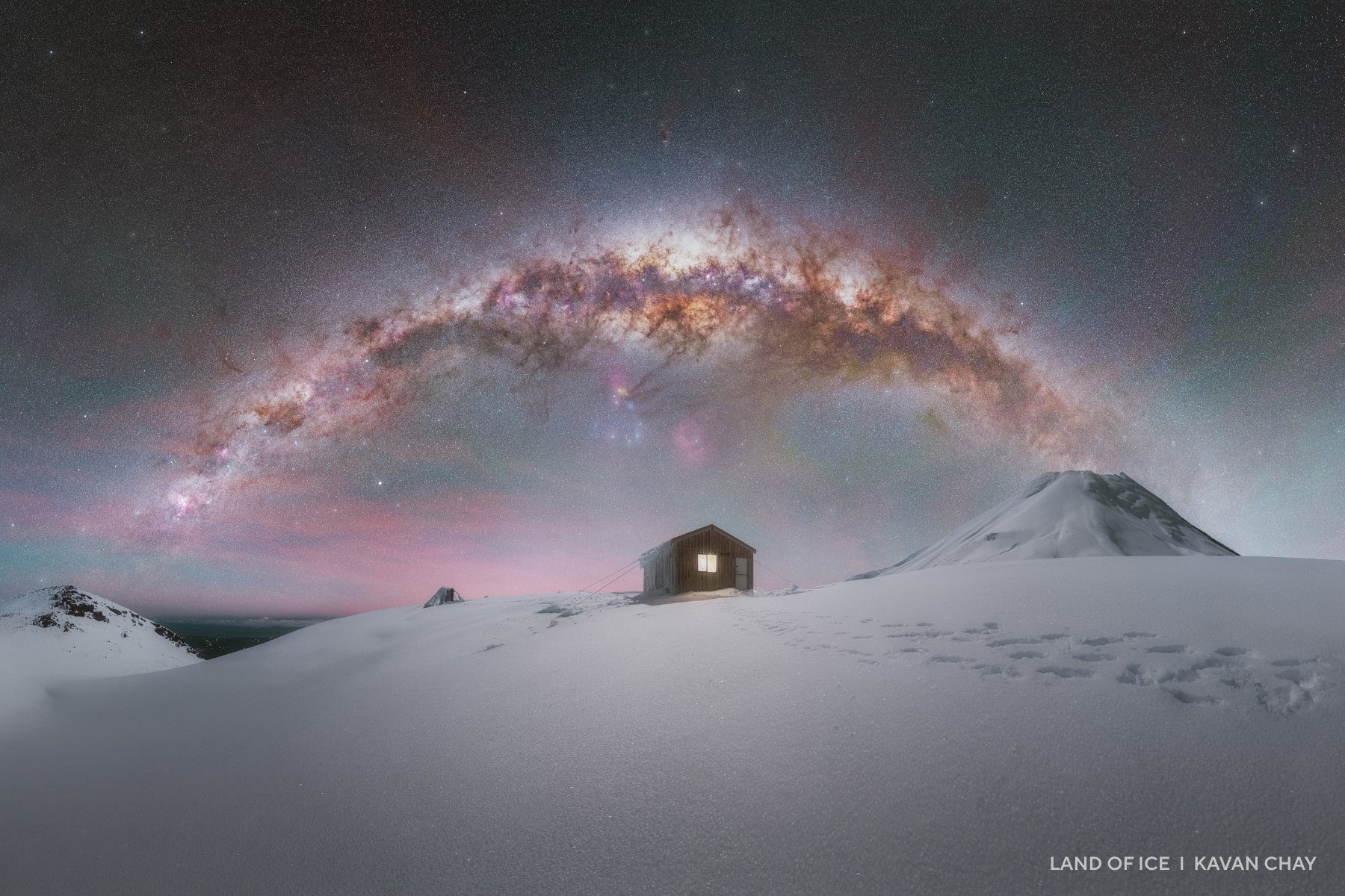 The Milky Way over a snowy hilltop.