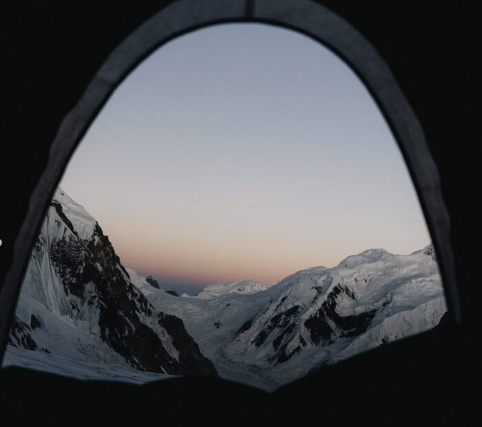 Mointains in dim light seen from the gate of a tent.