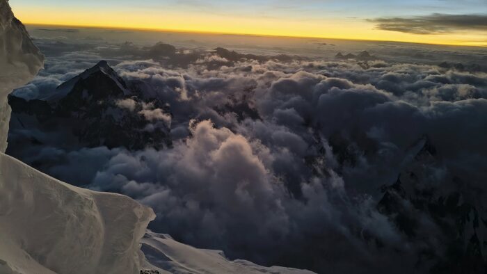 Sunlight on the horizon, above a sea of clouds. 