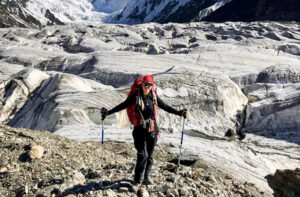 Natalia Nagovitsyna leaning on hiking poles in front of a glacier