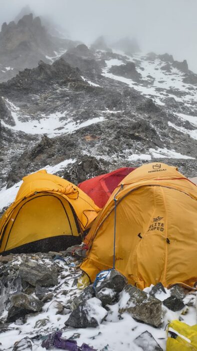 Tents on mostly rocky terrain in wet weather on K2