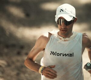 Close shot of Kilian Jornet in tshirt and cap during an ultra trial race.