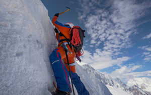 a climber gaining the top of a vertical ice section.