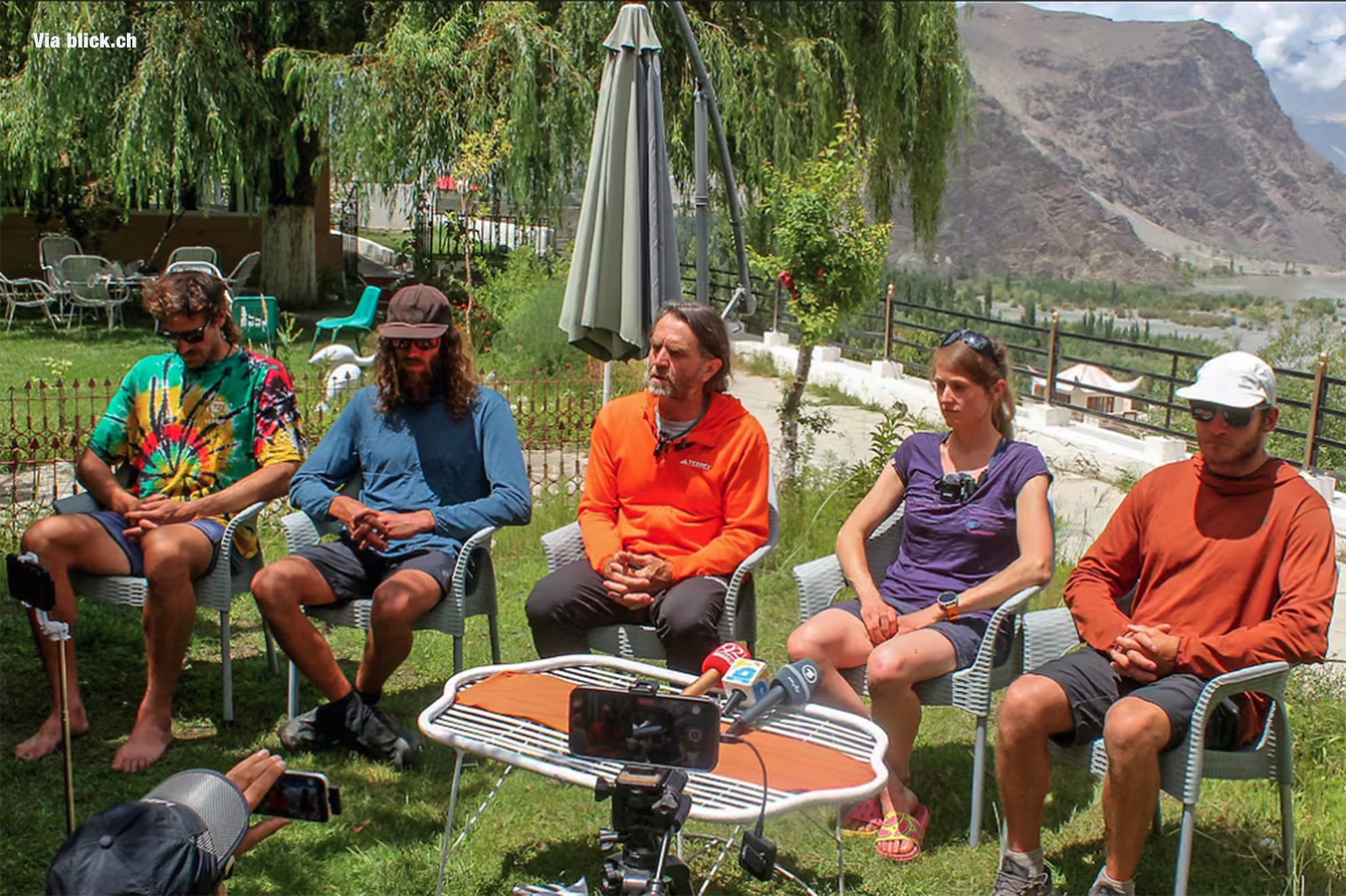 Marina Krauss and the international rescue team give a press conference while sitting at a garden in Skardu.