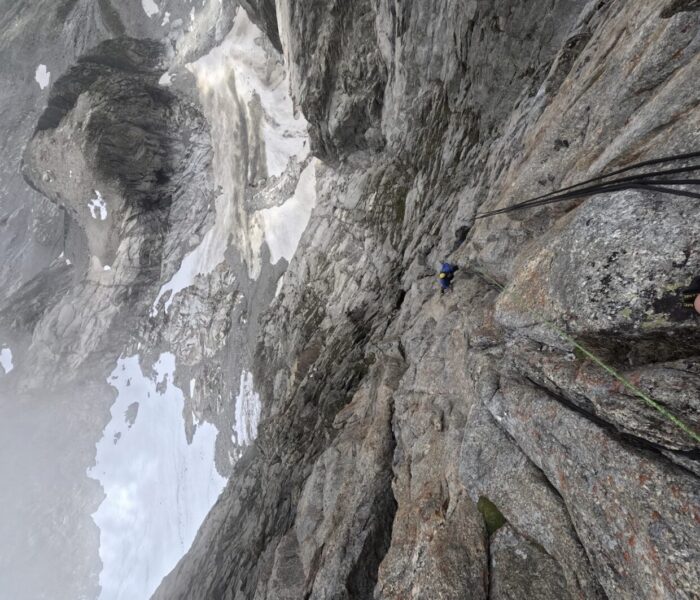 A climber in a misty day on a big wall face in the Mont Blanc massif.