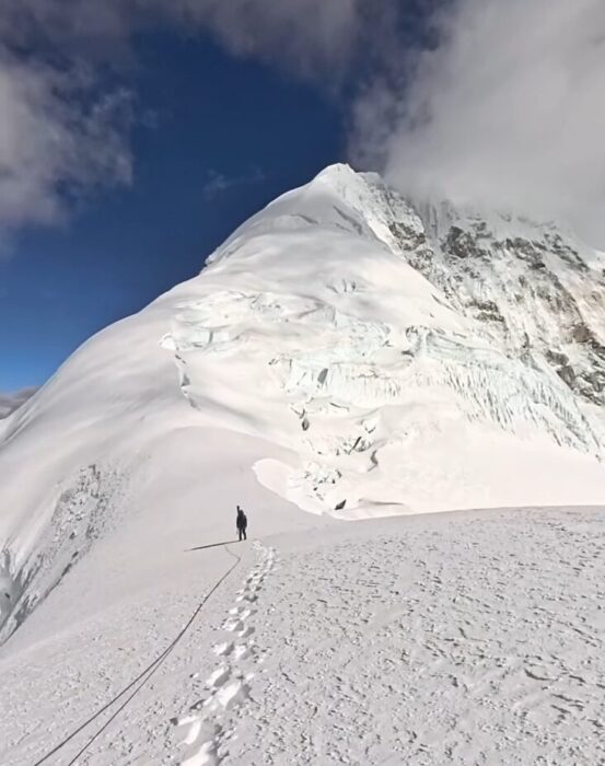Climbers roped up progress up the snowy, wide ridge of Baruntse. 