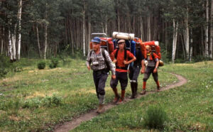 three hikers walking in a line on a trail