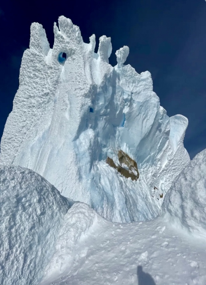 Looking up the last pitch from atop the penultimate pitch. The serac scar is clearly visible, and the false tunnel is the hole a bit tot the right of the central arete. 