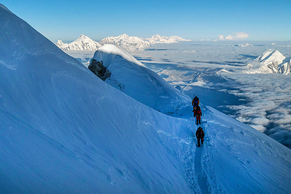 Soria descends on the shady side of the mountain, with shepas in front and behind.