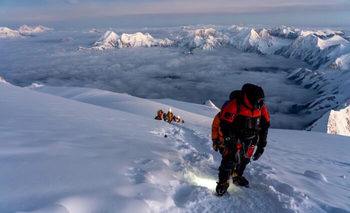 Climbers on a snow slope on Manaslu at dawn. 