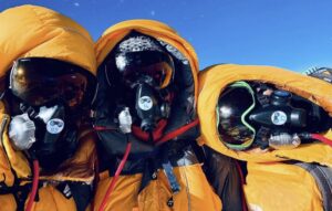 three guys in O2 masks and yellow down parkas