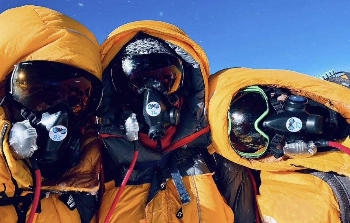 three guys in O2 masks and yellow down parkas