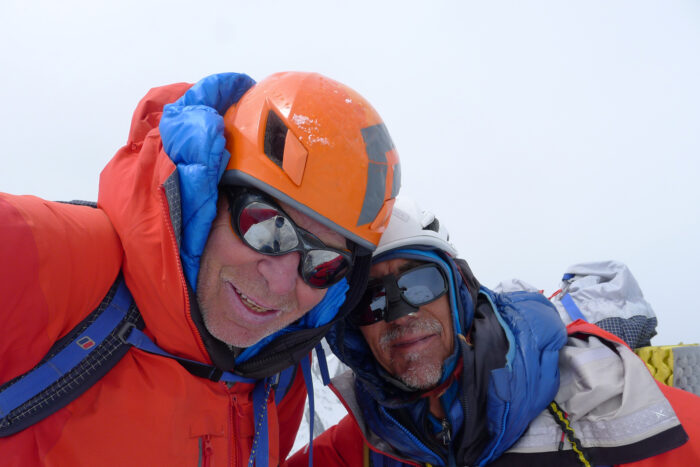 Close shot of Fowler and Saunders on a summit in a cloudy day. 