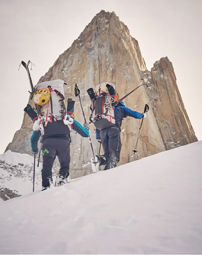 two skiers against spiky peak