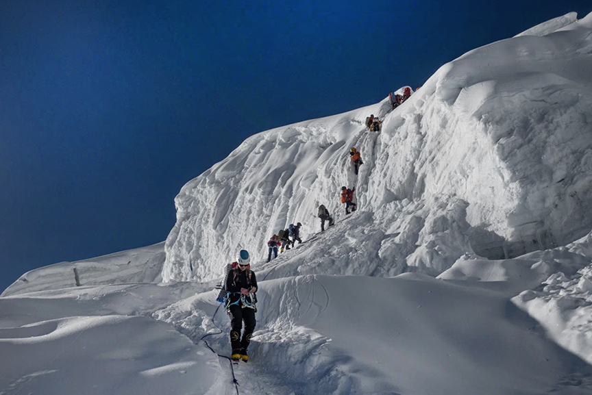 climbers climbing block of ice and snow
