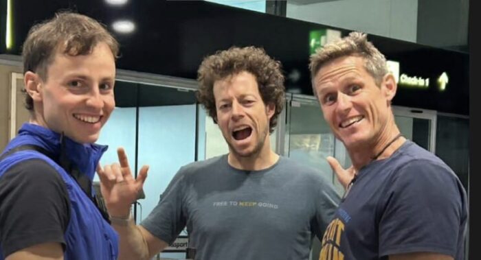 Climbers joking at an airport departures lounge. 