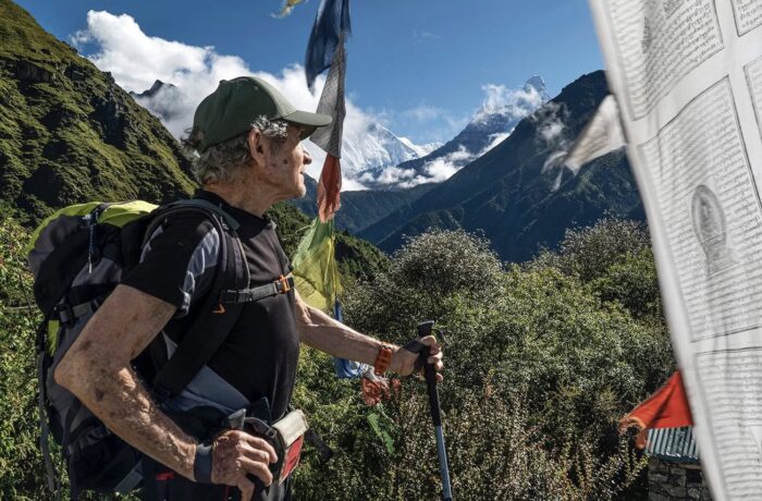 Carlos Soria, in t-shirt and cap, looks at the Khumbu peaks.