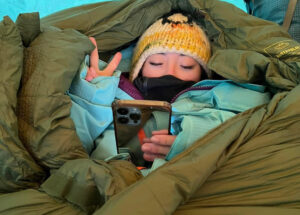 Tseng in a tent with a cellphone