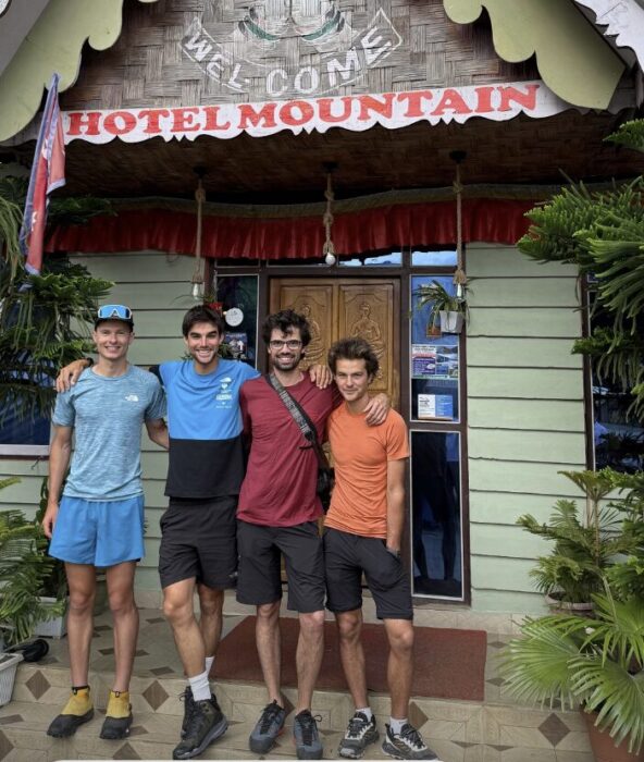 The JAnnu team pose standing in front of a lodge's door in Taplejung, Nepal.