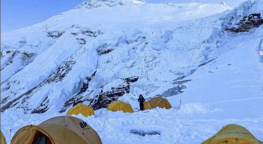 Some tents on the snow with Manaslu's summit in the background.