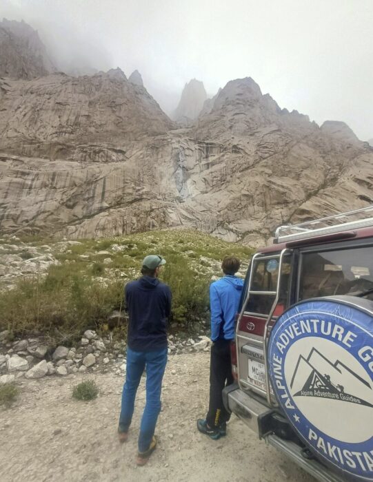 Climbers check granite peaks from beside their car. 