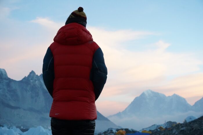 Tyler Andrews staring at the landscape at dawn, photographed from behind. 